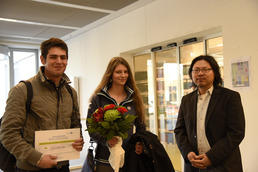 Blumenstrauß und Büchergutschein zur Eröffnung: Der Leiter der Campusbibliothek Martin Lee (rechts) begrüßte die ersten Besucher persönlich.