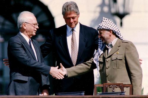 An iconic moment in 1993: Bill Clinton (center) hosts the signing ceremony for the Oslo I Accord. He is joined by Israeli Prime Minister Yitzhak Rabin (left) and Palestinian Liberation Organization (PLO) Chairman Yasser Arafat (right).